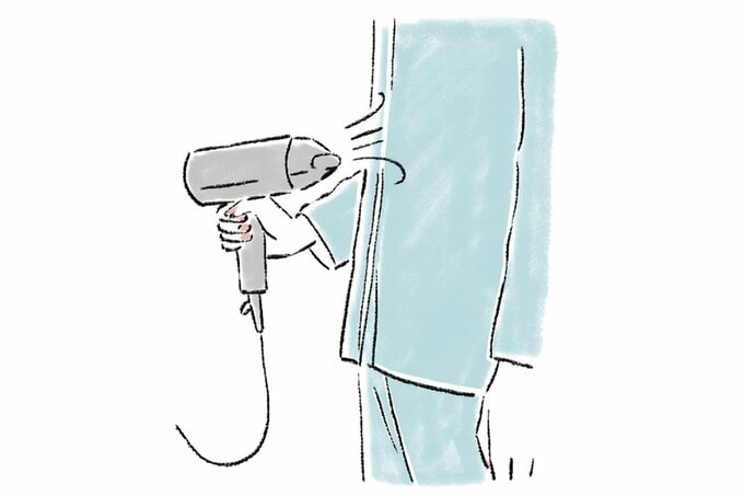 ドライヤーで腹部を温める様子のイラスト