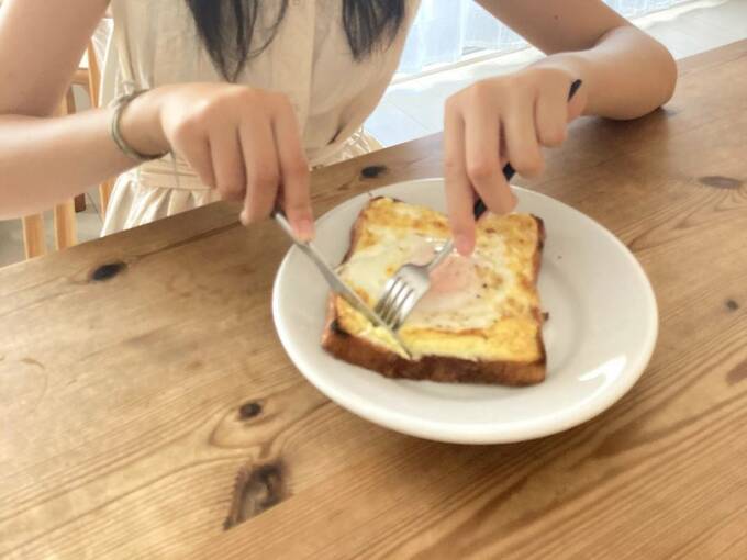 卵のせトーストを食べている女性