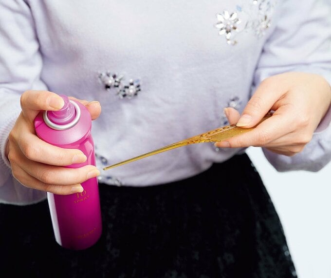 コームの柄にヘアスプレーを吹きかける