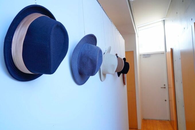 廊下のピクチャーレールに帽子をかける