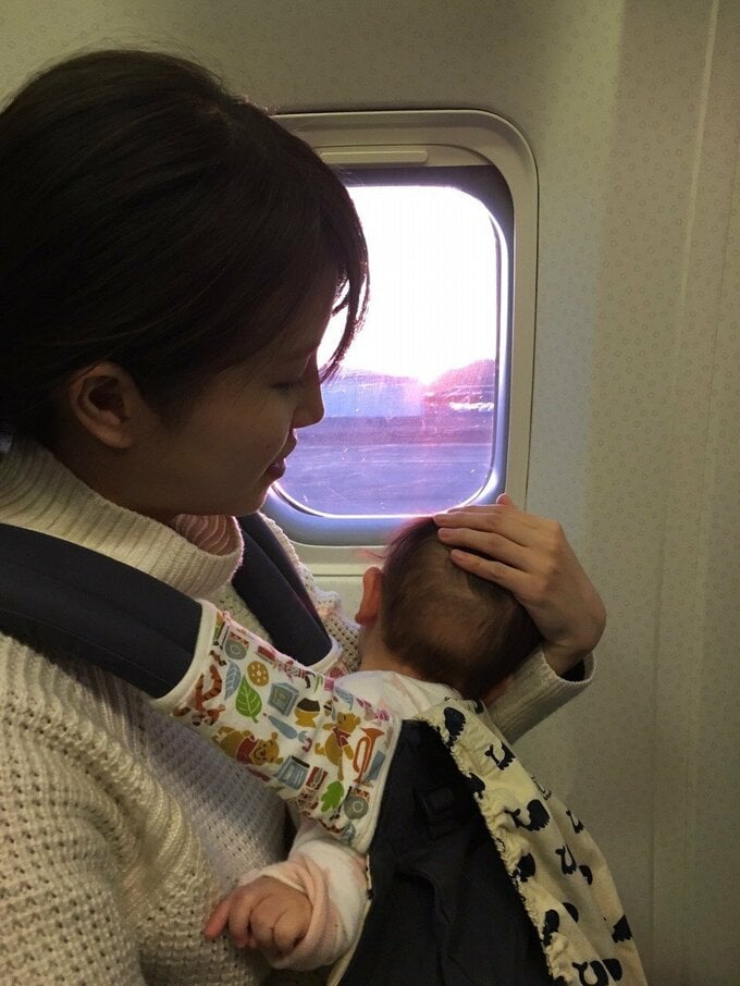 飛行機に乗る女性と赤ちゃん