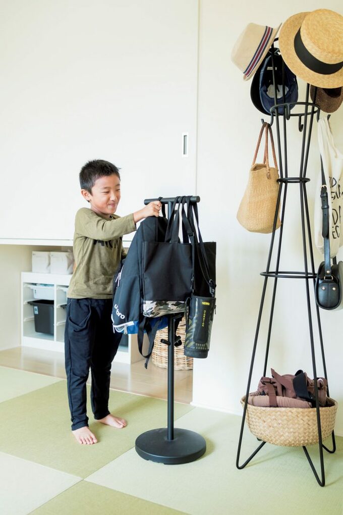 ラックに荷物をかける男の子