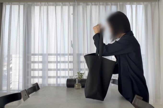 テーブルに鞄を置く女性