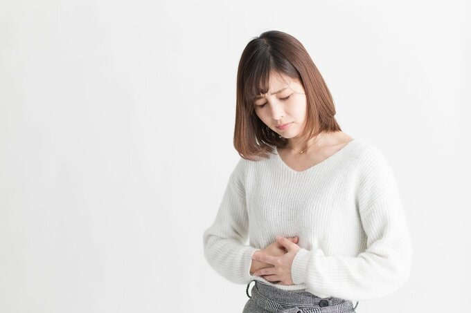 おなかをおさえる女性