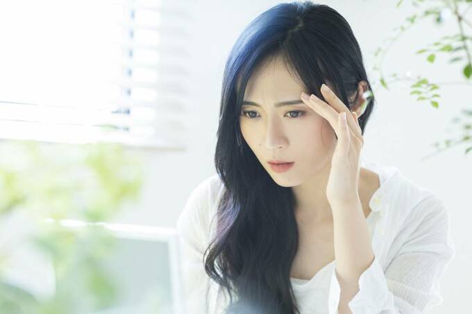 頭をおさえる女性