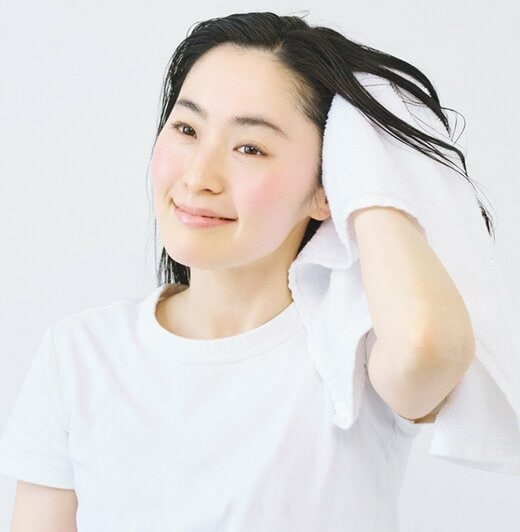 タオルで頭皮の水気をとる女性