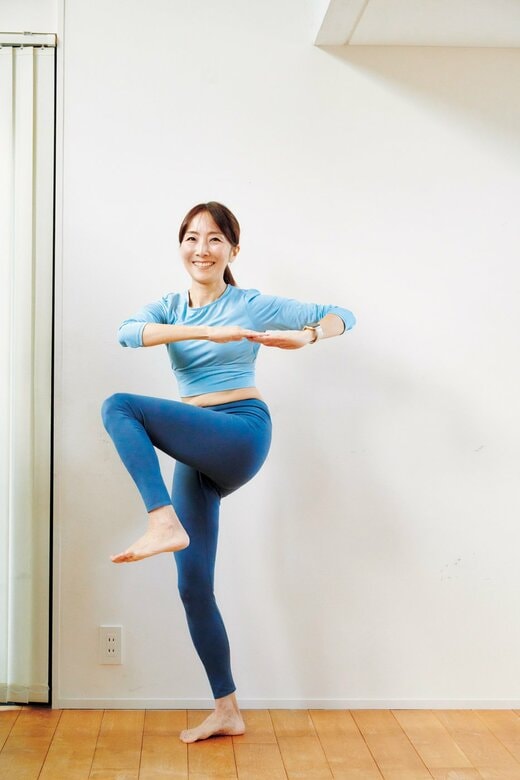 両肘を左右に開いて、左ひざを高く上げて脇腹をひねるアイミキさん