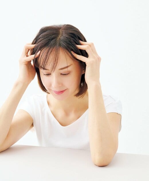 ハチの辺りを指で押し上げる女性