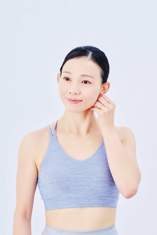 左手で左の胸鎖乳突筋をほぐす女性