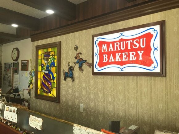 カウンター後ろの壁には、ステンドグラスや昔ながらの看板も。