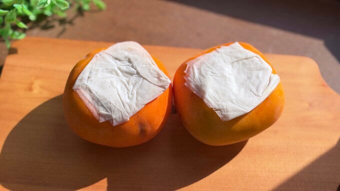 柿のヘタにキッチンペーパーをかぶせている