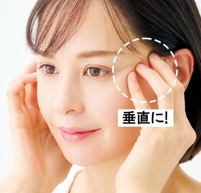 こめかみを指で押す女性