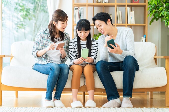 スマホをいじる家族