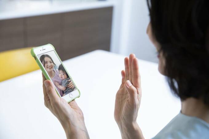 スマホに手を振る女性