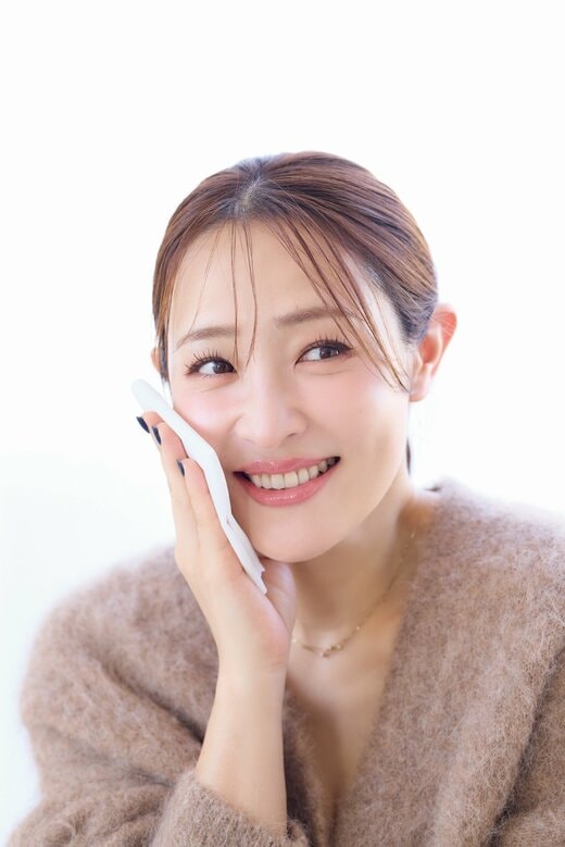 ティッシュで頬を押さえる女性