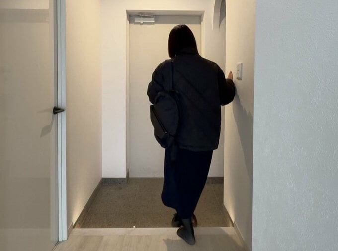 玄関で靴を脱ぐNozomiさんの後ろ姿