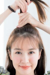 正面女性トップの毛を両手で持ち上げる