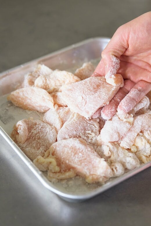 鶏胸肉に粉をまぶす様子