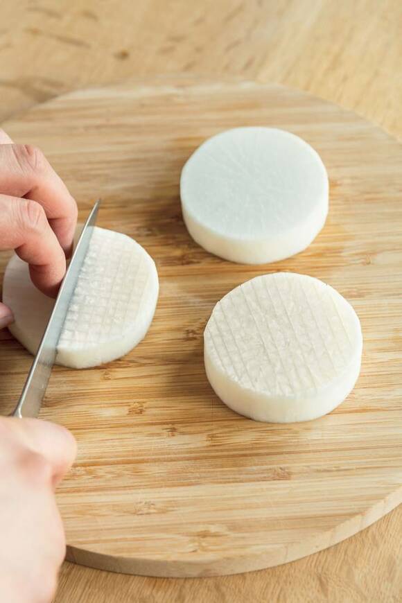 輪切り大根に切れ目を入れる様子