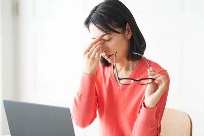 眉間を押さえる女性のイメージ画像