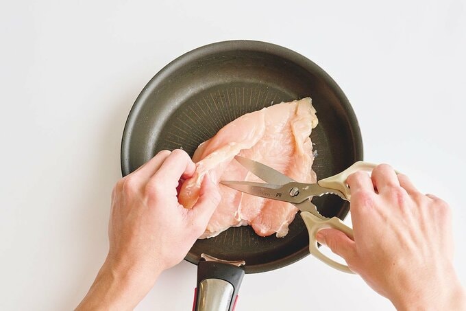 鶏胸肉をキッチンバサミで厚みを切り開いて広げているところ