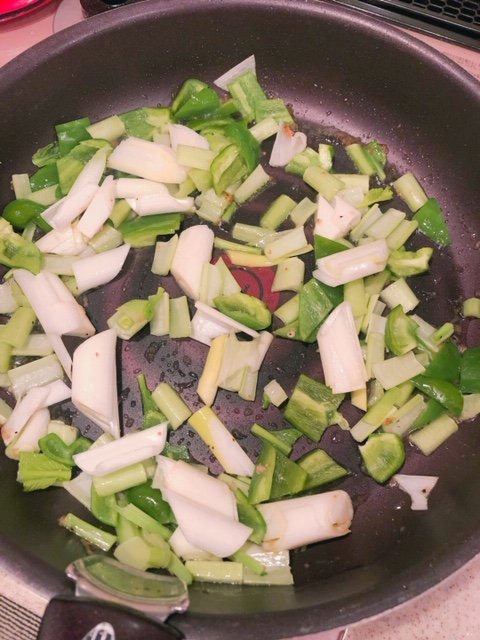 コマツナの茎の部分を炒める様子