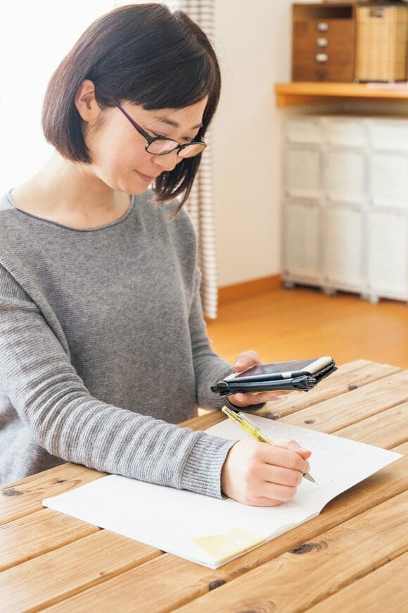 家計簿に書き込む様子