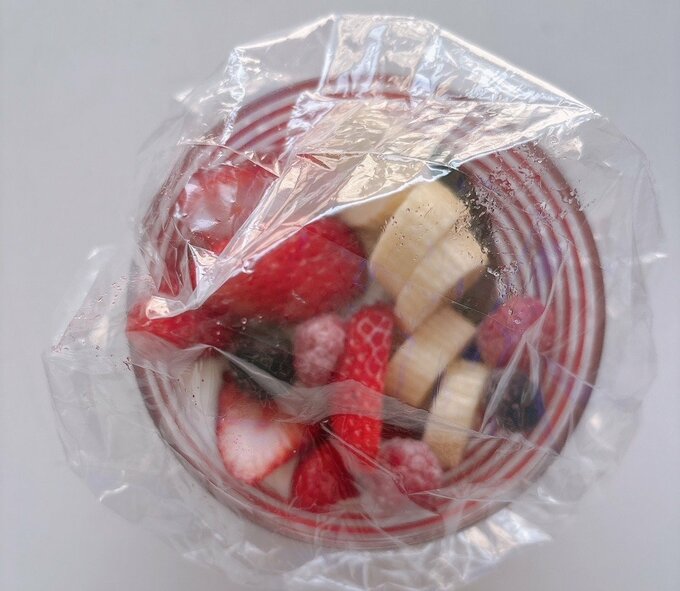 写真:フルーツをのせた皿にキャップをのせる様子