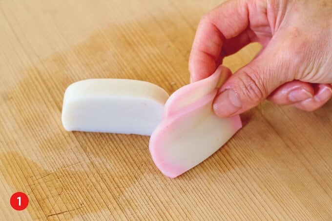 まな板の上に乗った切れた紅白のかまぼこ