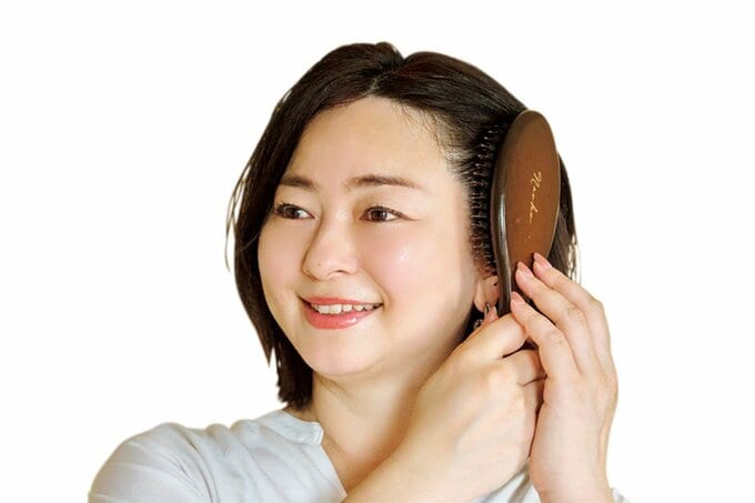 女性がヘアブラシで髪をとく様子