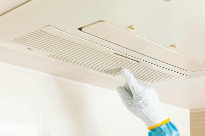 換気扇を軍手で触っている
