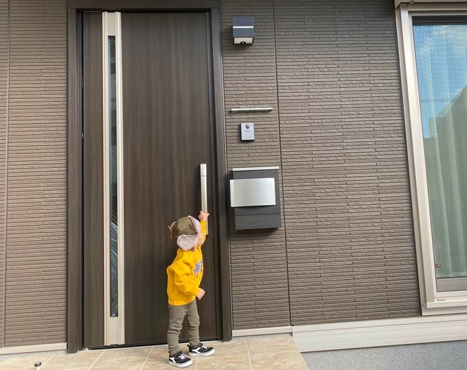 玄関ドアをあけようとしている息子