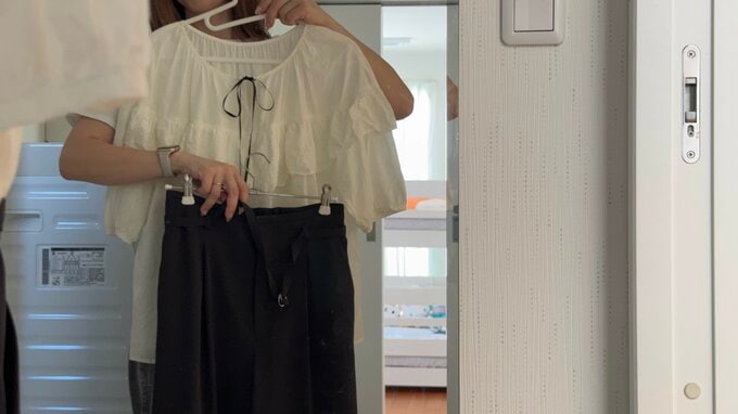 鏡の前で服を合わせている