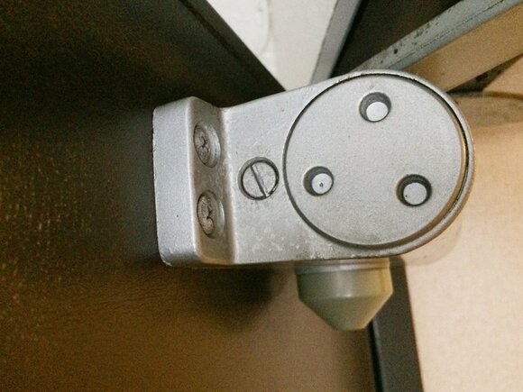 写真のドアクローザーの調整ネジは、3つのくぼみがある円の左横のもの