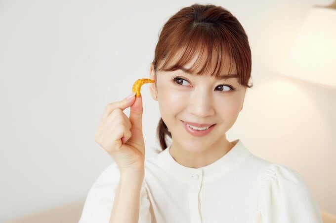 ラー油せんべいを手にする君島十和子さん