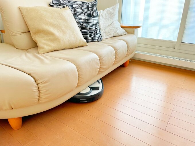 ソファの下を掃除するロボット掃除機