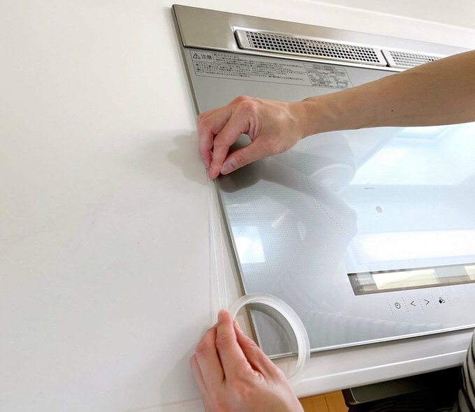 クッキングヒーターの縁に貼る様子