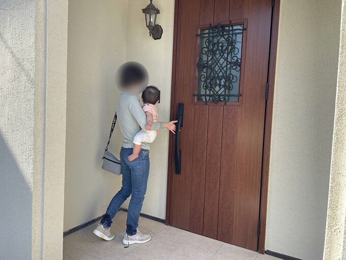 子どもを抱っこしてドアをあける