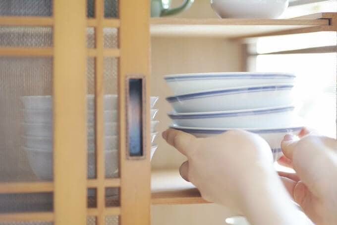 食器棚に食器を入れる様子