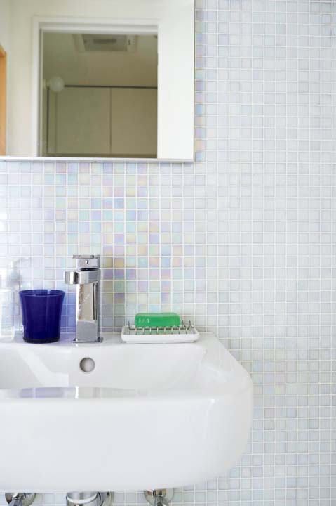 壁面をモザイクタイルで仕上げた洗面台まわり