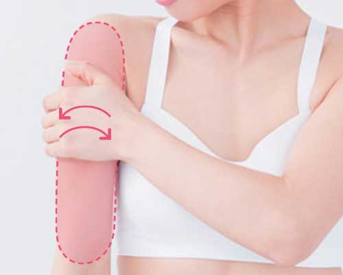 二の腕の外側の皮膚をねじる様子