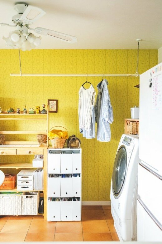 キッチンに設置された洗濯機と天井から吊下がる物干し竿