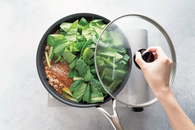 コマツナが入ったフライパンにフタをする様子