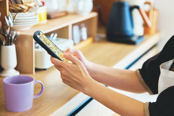 コーヒーを飲みながらスマホを見ている様子