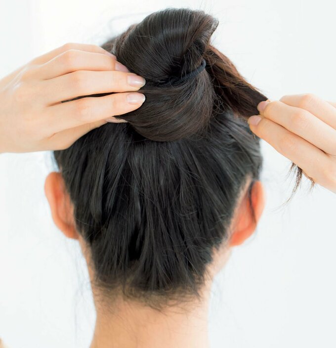 後ろ向き女性両手でお団子作成途中