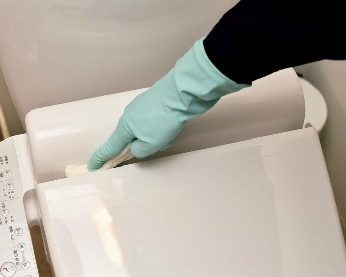 便座と水洗タンクの間をふく様子