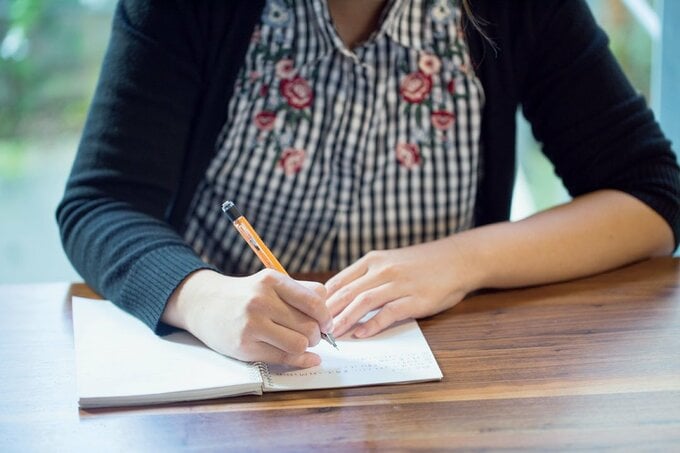 ノートにメモする女性