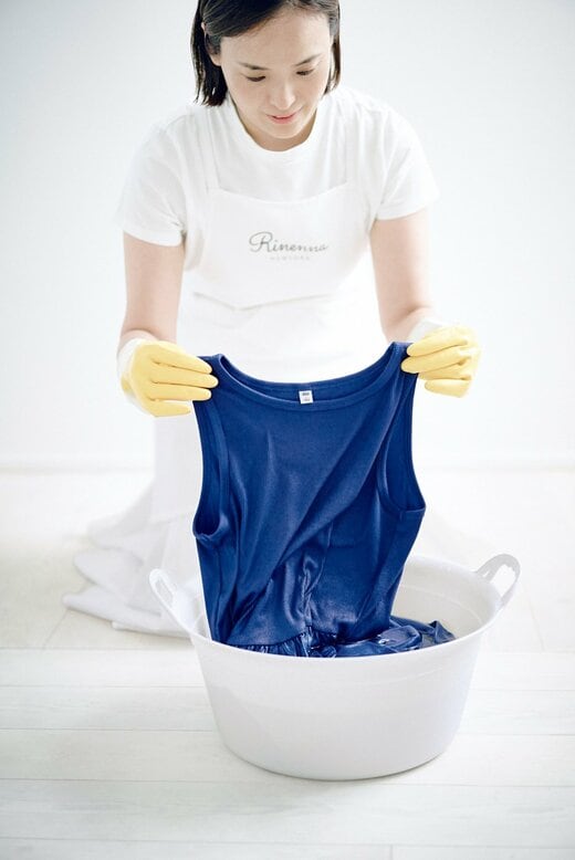 ブルーのワンピースを手洗いする女性