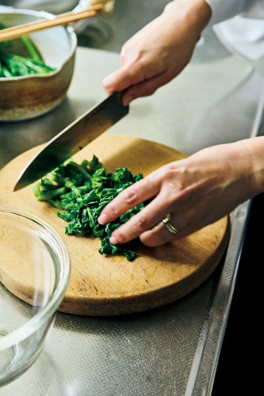 まな板の上の野菜を包丁で切る様子