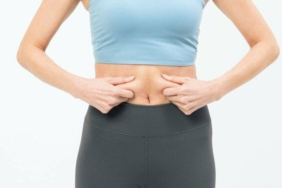 おなかの肉をつまむ